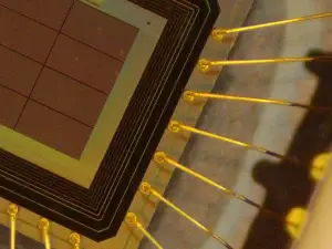 Close-up of a quantum random number generator (QRNG) microchip with gold bonding wires