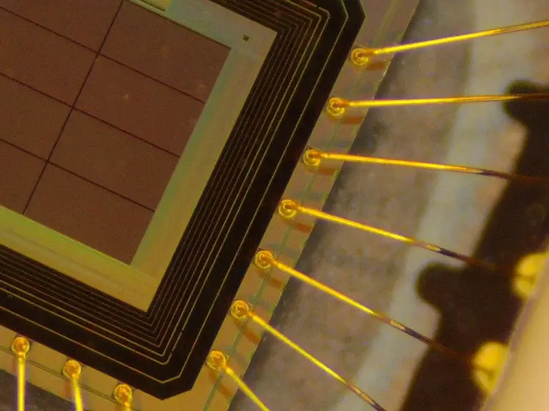 Close-up of a quantum random number generator (QRNG) microchip with gold bonding wires
